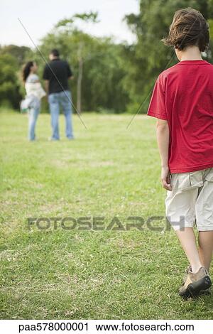 Boy walking sulkily toward parents having conversation distance View Large Photo Image Stock Image - Boy walking sulkily toward parents having conversation distance. Fotosearch