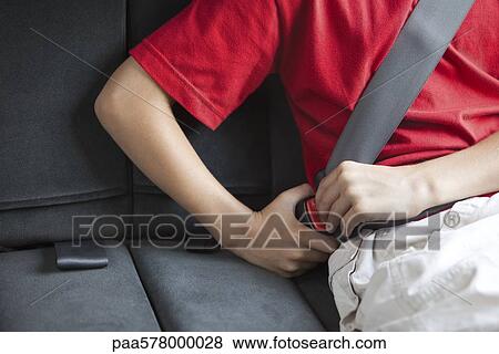 Stock Photo - Child fastening car seat belt. Fotosearch