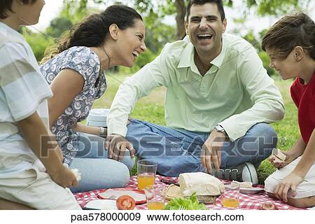 Stock Photo - Family enjoying picnic outdoors. Fotosearch
