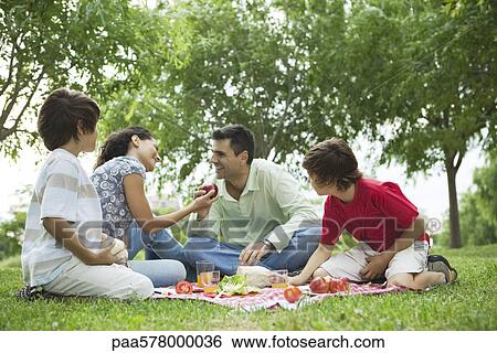Family enjoying picnic outdoors View Large Photo Image Stock Photograph - Family enjoying picnic outdoors. Fotosearch