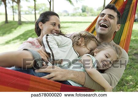Family laughing together on hammock View Large Photo Image Stock Image - Family laughing together on hammock. Fotosearch