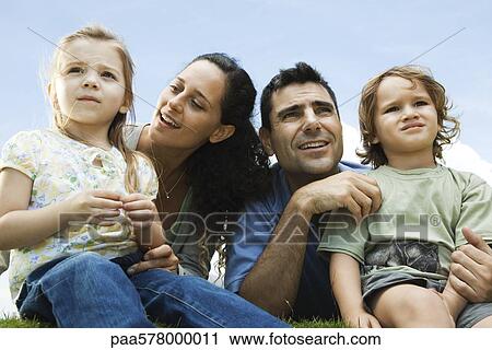 Stock Image - Family sitting together outdoors. Fotosearch
