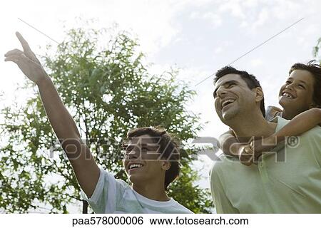 Stock Photograph - Father and sons exploring together outdoors. Fotosearch