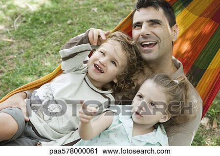 Father and two children relaxing together in hammock View Large Photo Image Stock Image - Father and two children relaxing together in hammock. Fotosearch