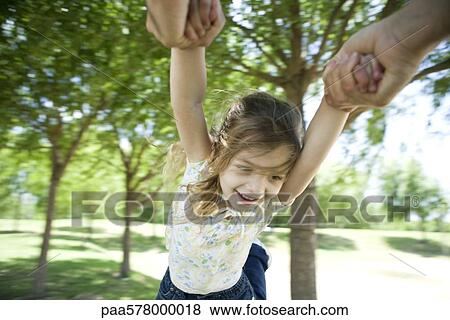 Little girl being swung through air by her arms View Large Photo Image Stock Photo - Little girl being swung through air by her arms. Fotosearch