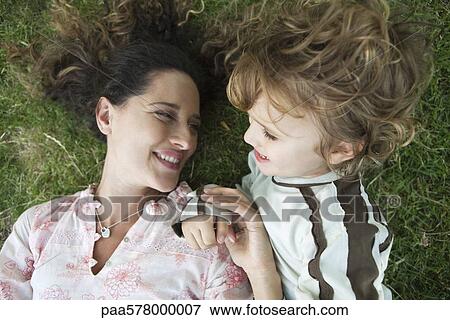 Stock Photo - Mother and young son lying on the ground together. Fotosearch