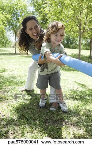 Mother and young son playing tug-of-war View Large Photo Image Stock Image - Mother and young son playing tug-of-war. Fotosearch
