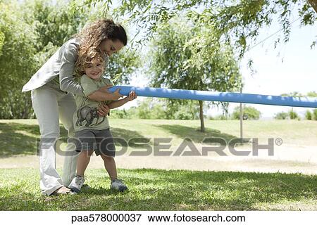 Mother helping young son play tug-of-war View Large Photo Image Stock Photo - Mother helping young son play tug-of-war. Fotosearch