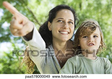 Mother pointing out something to young son outdoors View Large Photo Image Stock Photo - Mother pointing out something to young son outdoors. Fotosearch