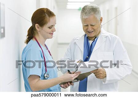 Doctor and nurse discussing medical chart View Large Photo Image Stock Image - Doctor and nurse discussing medical chart. Fotosearch