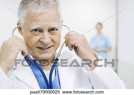 Doctor putting on stethoscope, portrait View Large Photo Image Stock Photography - Doctor putting on stethoscope, portrait. Fotosearch