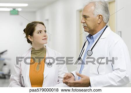Doctor talking with female colleague View Large Photo Image Stock Photo - Doctor talking with female colleague. Fotosearch