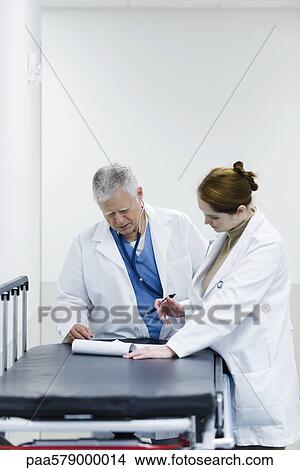 Doctors discussing medical chart View Large Photo Image Picture - Doctors discussing medical chart. Fotosearch