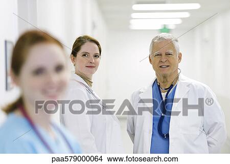 Picture - Doctors together in corridor, portrait. Fotosearch