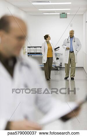 Doctors walking down hospital corridor View Large Photo Image Stock Photo - Doctors walking down hospital corridor. Fotosearch