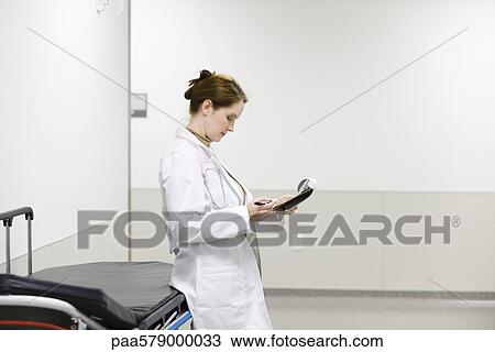Female doctor looking at medical chart View Large Photo Image Stock Image - Female doctor looking at medical chart. Fotosearch