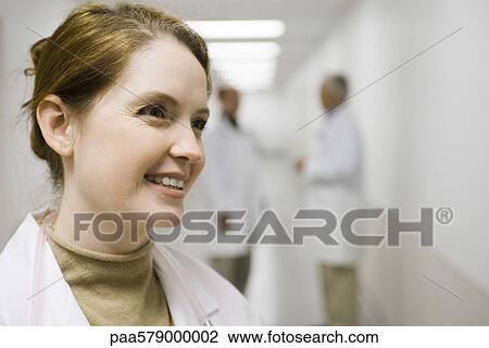 Healthcare worker smiling, looking away, portrait View Large Photo Image Stock Image - Healthcare worker smiling, looking away, portrait. Fotosearch