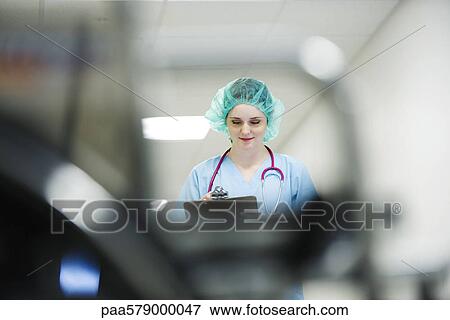 Stock Photo - Nurse wearing surgical cap, low angle view. Fotosearch