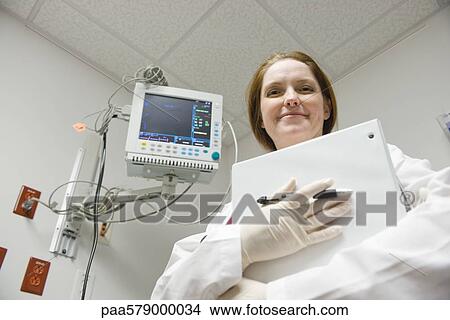 Nurse with binder, low angle view View Large Photo Image Picture - Nurse with binder, low angle view. Fotosearch