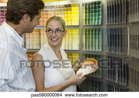 Picture - Couple looking at color swatches in store. Fotosearch