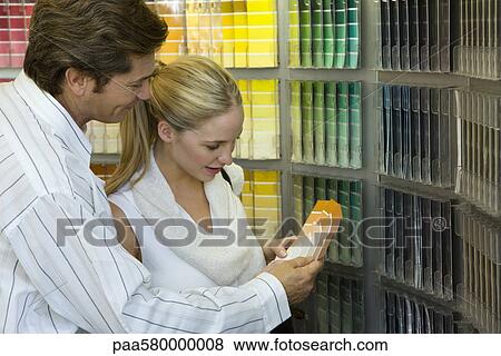 Stock Photo - Couple looking at color swatches in store. Fotosearch