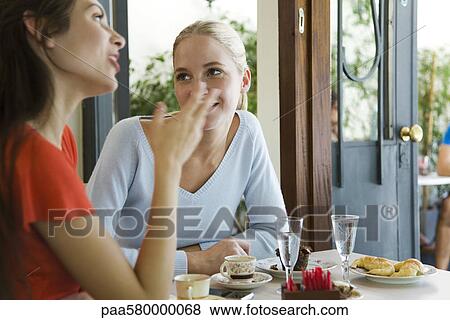 Stock Photo - Female friends at cafe. Fotosearch