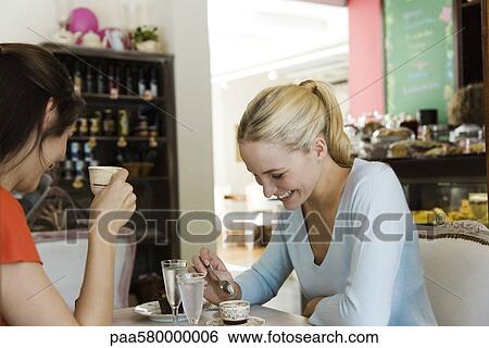 Female friends having coffee in cafe View Large Photo Image Stock Photograph - Female friends having coffee in cafe. Fotosearch