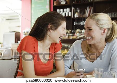 Female friends together at cafe, laughing View Large Photo Image Stock Image - Female friends together at cafe, laughing. Fotosearch