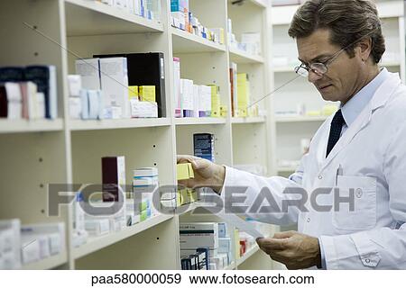 Pharmacist checking shelf for medication View Large Photo Image Stock Photo - Pharmacist checking shelf for medication. Fotosearch