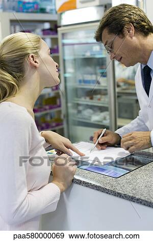 Pharmacist explaining prescription to customer View Large Photo Image Stock Photo - Pharmacist explaining prescription to customer. Fotosearch