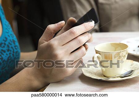 Woman holding cell phone, close-up View Large Photo Image Picture - Woman holding cell phone, close-up. Fotosearch