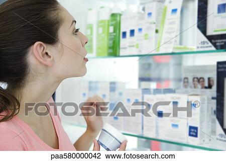 Young woman browsing beauty products in store View Large Photo Image Stock Image - Young woman browsing beauty products in store. Fotosearch