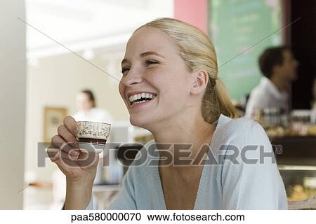 Young woman drinking coffee at cafe View Large Photo Image Stock Image - Young woman drinking coffee at cafe. Fotosearch