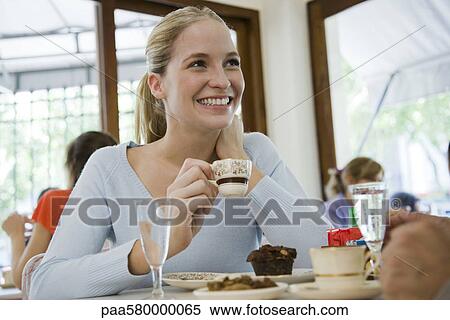 Young woman drinking coffee at cafe View Large Photo Image Stock Photography - Young woman drinking coffee at cafe. Fotosearch