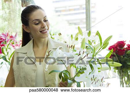 Young woman holding lilies, portrait View Large Photo Image Stock Photo - Young woman holding lilies, portrait. Fotosearch