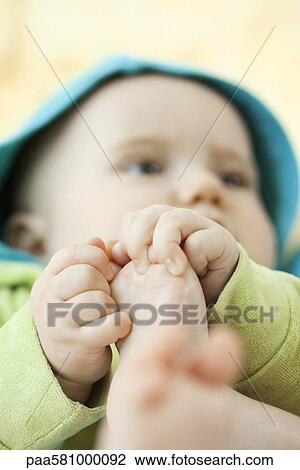 Stock Image - Baby holding its toes. Fotosearch
