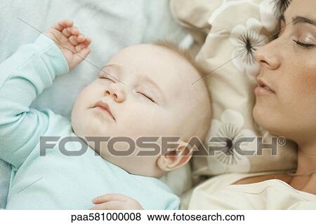 Baby napping with mother View Large Photo Image Stock Photo - Baby napping with mother. Fotosearch