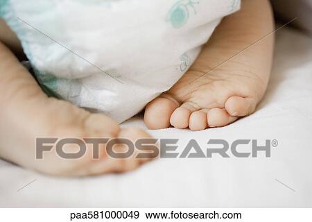 Baby's diaper and bare feet, close-up View Large Photo Image Stock Photo - Baby's diaper and bare feet, close-up. Fotosearch