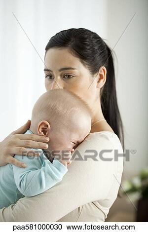 Stock Image - Mother comforting crying infant. Fotosearch