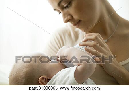 Mother feeding infant with baby bottle View Large Photo Image Stock Photography - Mother feeding infant with baby bottle. Fotosearch