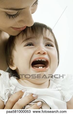 Stock Image - Mother holding crying infant. Fotosearch