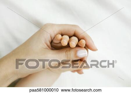 Mother holding infant's hand, close-up View Large Photo Image Stock Image - Mother holding infant's hand, close-up. Fotosearch