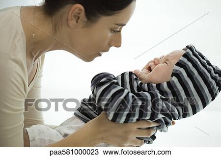 Mother picking up crying infant View Large Photo Image Stock Image - Mother picking up crying infant. Fotosearch