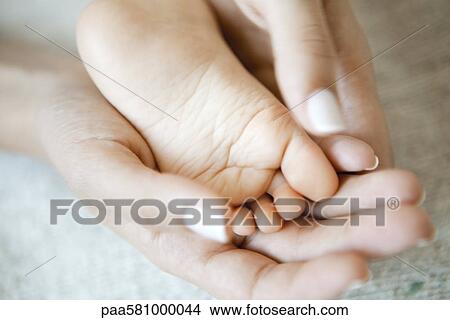 Woman's hands holding baby's foot View Large Photo Image Picture - Woman's hands holding baby's foot. Fotosearch