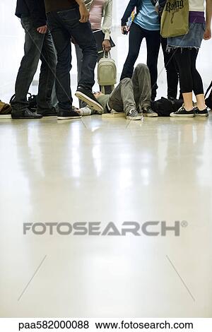 Bullies surrounding and threatening teenage boy lying on floor View Large Photo Image Stock Photo - Bullies surrounding and threatening teenage boy lying on floor. Fotosearch