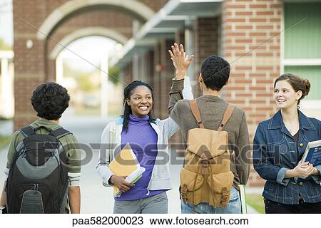 Stock Image - Classmates giving each other high-five. Fotosearch