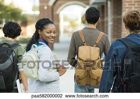 Stock Image - College student walking with friends. Fotosearch