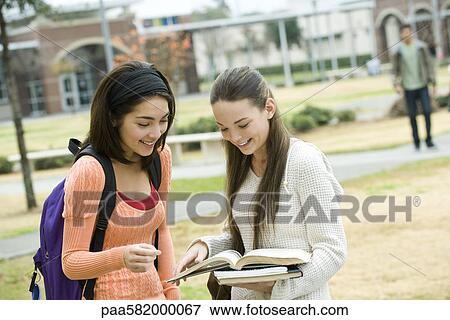 High school friends looking at book together View Large Photo Image Stock Photo - High school friends looking at book together. Fotosearch