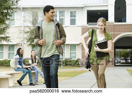 Stock Photograph - High school friends walking together on campus. Fotosearch