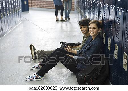 High school student sitting on floor with friend by lockers in school corridor View Large Photo Image Stock Photograph - High school student sitting on floor with friend by lockers in school corridor. Fotosearch